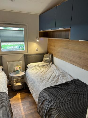 ein kleines Schlafzimmer mit einem Bett und einem Tisch in der Unterkunft Ferienhaus Feldblick in Fehmarn
