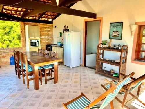una cucina con tavolo, sedie e frigorifero di Loft NOA'House a Canoa Quebrada