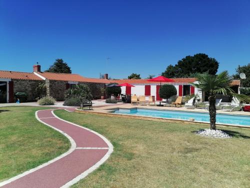 une passerelle à côté d'une piscine à côté d'une maison dans l'établissement La Longère des Olonnes, à Les Sables-dʼOlonne