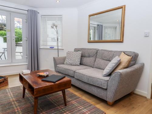 a living room with a couch and a mirror at Lower Deck in Bexhill