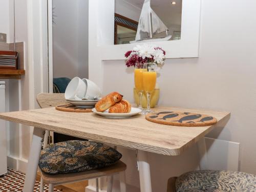 a table with a plate of bread and orange juice at Lower Deck in Bexhill