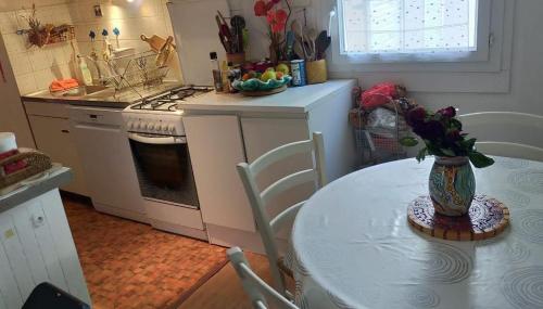 uma cozinha com uma mesa com um vaso sobre ela em Chambre hôte Residence sous les pins em Cassis