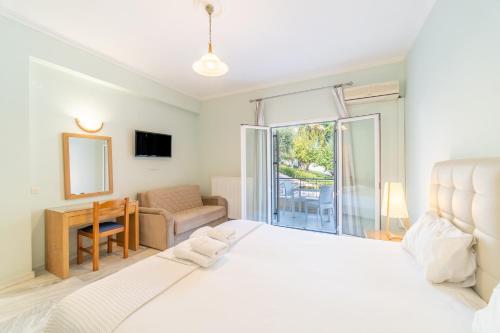 a bedroom with a large white bed and a window at St Nicholas B6 Beach Garden View ii in Dafnila