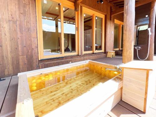 OWL RESORT ARIFUKU ONSEN في Gotsu: حوض استحمام ساخن على جانب المبنى