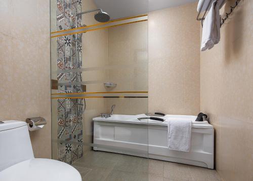 a bathroom with a sink and a mirror and a toilet at Palace Gate Hotel & Resort By EHM in Phnom Penh