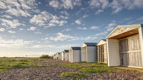 a row of beach houses on a gravel road at Modern Seaside Townhouse feat Sauna near Brighton in Shoreham-by-Sea