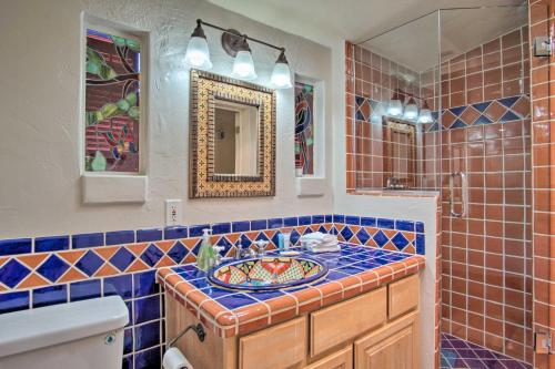 a blue tiled bathroom with a sink and a mirror at Stylish Tucson Home Backyard Oasis with Grill! in Tucson
