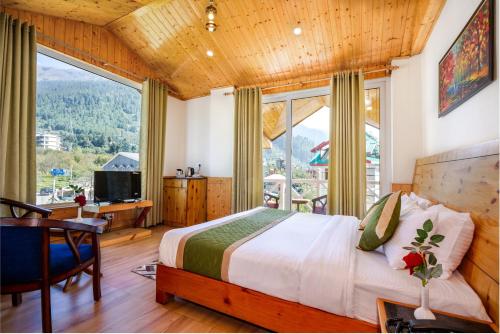 Tripli Hotels Stone House Cottage في مانالي: غرفة نوم بسرير ومكتب ونافذة