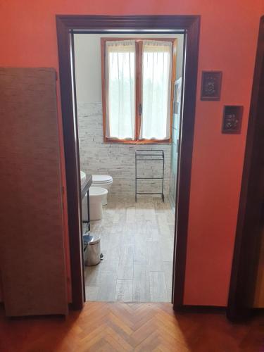a bathroom with a toilet and a window at Villa Ferrari Oriella in Solignano Nuovo
