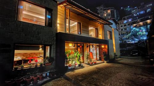 a store with potted plants on a street at night at Royale Retreat Hotel & Spa Near Mall Road in Shimla