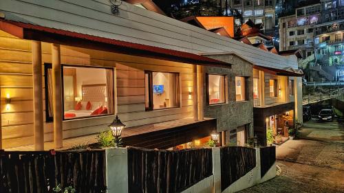 a house with a balcony in a city at night at Royale Retreat Hotel & Spa Near Mall Road in Shimla