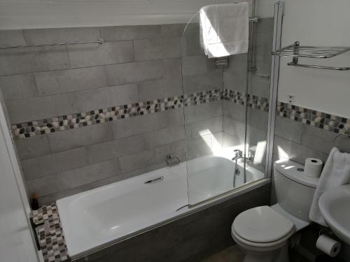 ein Badezimmer mit Badewanne, Toilette und Waschbecken in der Unterkunft No 1 @ The Dunes in Plettenberg Bay