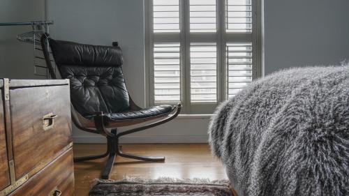 a leather chair sitting in a room with a window at Modern Seaside Townhouse feat Sauna near Brighton in Shoreham-by-Sea