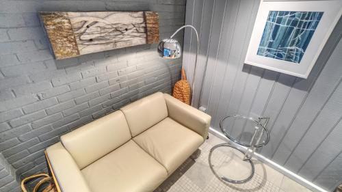a white couch in a room with a wall at Modern Seaside Townhouse feat Sauna near Brighton in Shoreham-by-Sea