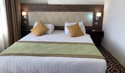 1 dormitorio con 1 cama grande y 2 almohadas en Up Town Hotel en El Cairo