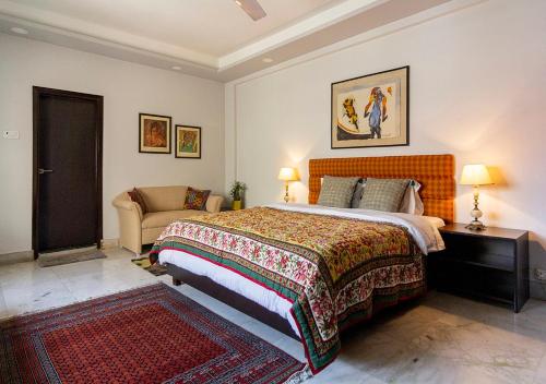 a bedroom with a large bed and a couch at Neelam Bed & Breakfast in Kolkata