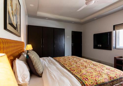 a bedroom with a bed and a flat screen tv at Neelam Bed & Breakfast in Kolkata