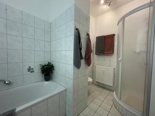 baño blanco con bañera y aseo en Moderne 3 Raum Altbau ETW bis 4 Gäste, Nähe Staatstheater, Parkplatz, Netflix, Vollausstattung, en Cottbus