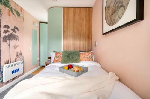 ein Schlafzimmer mit einem Bett und einem Tablett mit Obst darauf in der Unterkunft Travellers Tales - A Pod in the Cotswolds in Minster Lovell