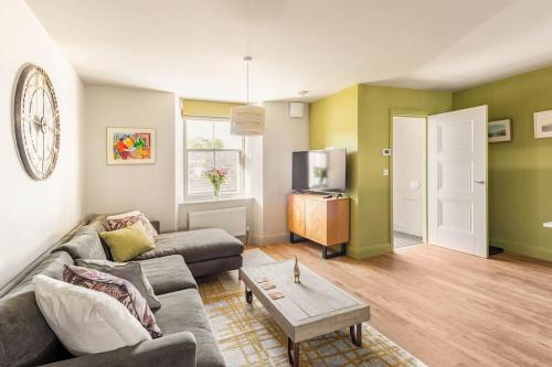 a living room with a couch and a table at Shamrock, Bowness on Windermere, Superb one bedroom apartment with private parking in Bowness-on-Windermere