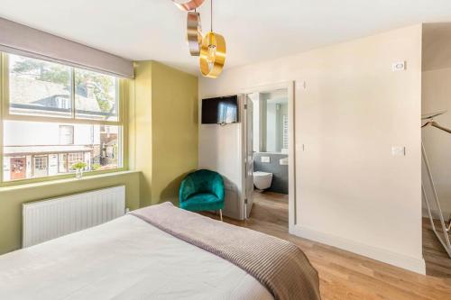 een slaapkamer met een bed en een groene stoel bij Shamrock, Bowness on Windermere, Superb one bedroom apartment with private parking in Bowness-on-Windermere
