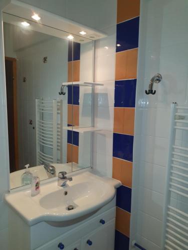 ein Bad mit einem Waschbecken und einem Spiegel in der Unterkunft M & M apartment Krvavec in Cerklje na Gorenjskem