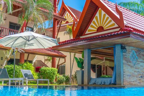 a house with a swimming pool and an umbrella at Sai Rougn apartment in Patong Beach