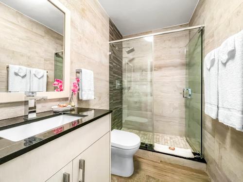 a bathroom with a toilet and a glass shower at Casa Pellegrino Boutique Hotel in Hollywood