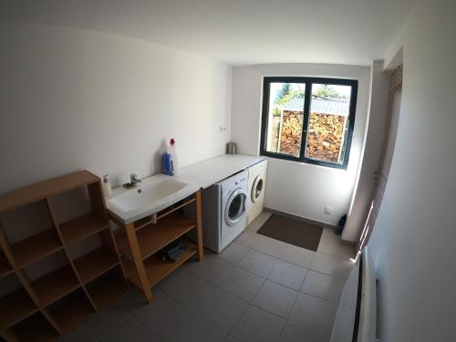 a kitchen with a sink and a washing machine at Maison neuve proche de Barcelonnette in Jausiers