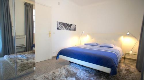 a bedroom with a blue bed and a mirror at Villa Ocean Breeze in Roquebrune-Cap-Martin