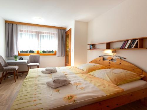 a bedroom with a large wooden bed with towels on it at Ferienbungalow Schultz in Altenkirchen in Altenkirchen