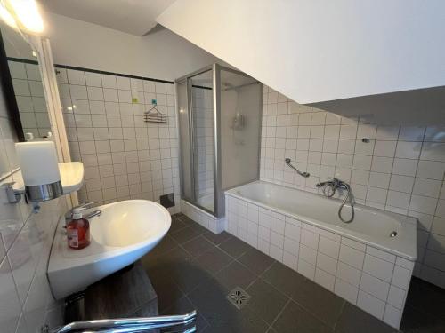 a bathroom with a tub and a sink and a bath tub at Hagmann's Altstadt Appartement in Krems an der Donau