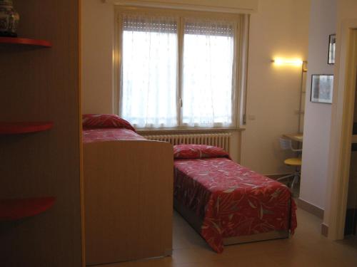 a small bedroom with a bed and a window at B&B Stazione in Canegrate