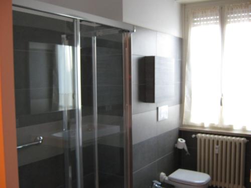 a bathroom with a glass shower with a toilet at B&B Stazione in Canegrate
