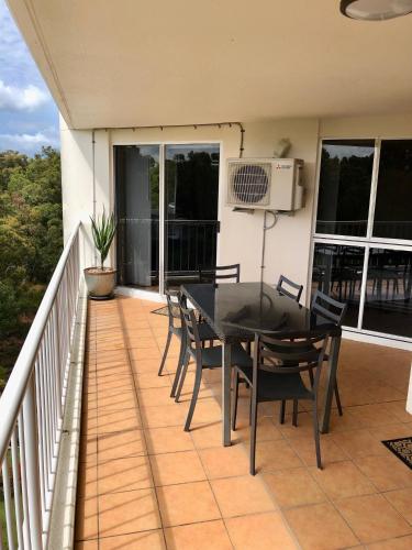 a patio with a table and chairs on a balcony at Fairways Golf & Beach Retreat Bribie Island in Woorim