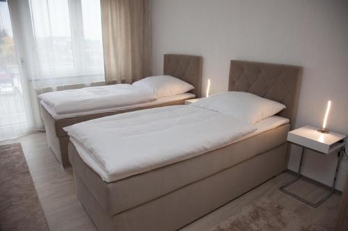 zwei Betten in einem Zimmer mit zwei Kerzen drauf in der Unterkunft T&K Apartments near Messe Fair Trade Düsseldorf und Airport 2B in Duisburg