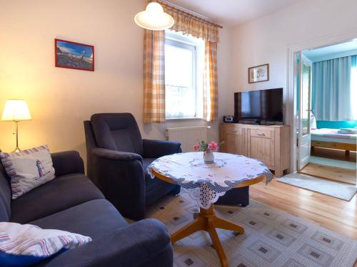 a living room with a couch and a table and a tv at Ferienwohnung Käthe in Altenkirchen in Altenkirchen