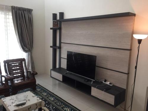 a living room with a fireplace with a tv at Koolest homestays Meru in Ipoh