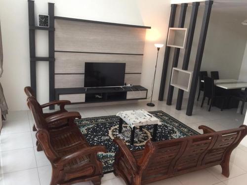 a living room with a tv and a chair and a table at Koolest homestays Meru in Ipoh