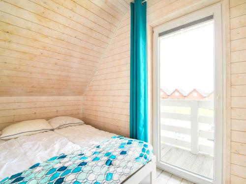 Habitación pequeña con cama y ventana en Holiday House Sarbinowo, en Sarbinowo