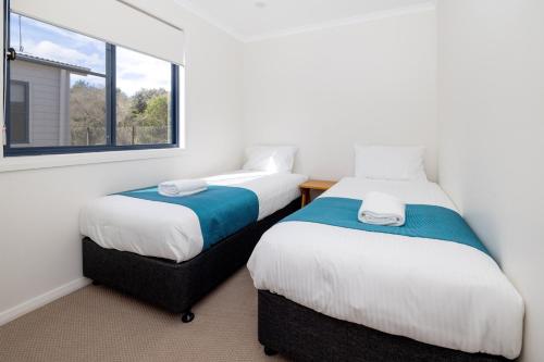 2 camas en una habitación con ventana en BIG4 Manning Point Holiday Park, en Manning Point