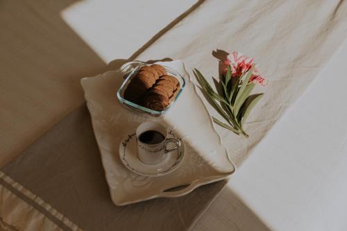 Un plato con un pastel y un jarrón de flores sobre una mesa. en Casalloro, en Valdagno