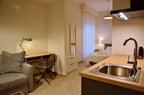 cocina con fregadero y escritorio con cama en Eutopia Luxury Studio, en Kavala
