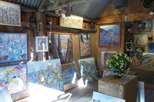 a room with many paintings on the wall at Orinoco Country Retreat in Ngatimoti
