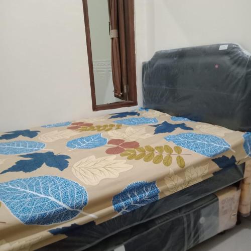 a bed with a comforter with leaves on it at Lavanta Guest House 