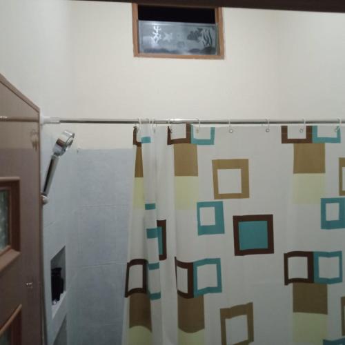 a bathroom with a shower curtain with a window at Lavanta Guest House 
