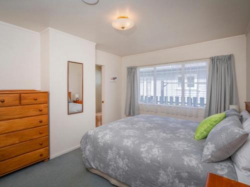 - une chambre avec un lit, une commode et une fenêtre dans l'établissement The Bach - Whangamata Holiday Home, à Whangamata