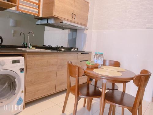 a kitchen with a table and chairs and a washing machine at vitamin SEA Timurbay Residence in Kuantan