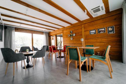 una sala da pranzo con tavolo e pareti in legno di Chaber Apartamenty a Swornegacie