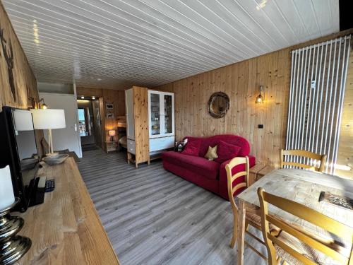 un salon avec un canapé rouge et une table dans l'établissement Aiguille Verte 28 - Studio avec vue, à La Clusaz